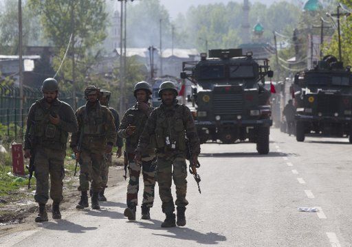 (180411) -- SRINAGAR, April 11, 2018 (Xinhua) -- Indian army troopers walk near the site of a gunfight in village Khudwani of Kulgam district, 59 km south of Srinagar, the summer capital of Indian-controlled Kashmir, April 11, 2018. At least three civilians and a trooper were killed Wednesday in ongoing clashes and gunfight in restive Indian-controlled Kashmir, officials said. (Xinhua\/Javed Dar)(rh)