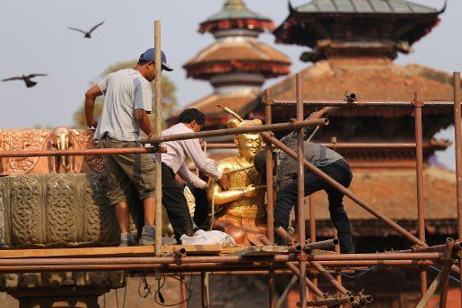 (180424) -- KATHMANDU, April 24, 2018 (Xinhua) -- Workers place the statue of Late King Pratap Malla which was damaged in the 2015 earthquake at Hanumandhoka Durbar Square, a UNESCO heritage site, in Kathmandu, Nepal, April 24, 2018. (Xinhua\/Sunil Sharma) (dtf)