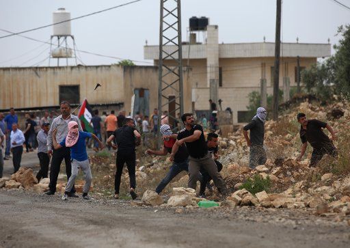 (180504) -- NABLUS, May 4, 2018 (Xinhua) -- Palestinian protesters hurl stones at Israeli soldiers during clashes after a protest against the expanding of Jewish settlements in Kufr Qadoom village near the West Bank city of Nablus, on May 4, 2018. Clashes broke out Friday between dozens of Palestinian protestors and Israeli soldiers in eastern Gaza Strip close to the border with Israel during the sixth Friday of rallies and protests called "the Great March of Return." (Xinhua\/Ayman Nobani)(srb)