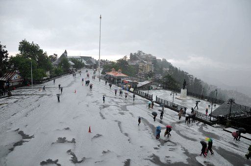 (180509) -- SHIMLA, May 9, 2018 (Xinhua) -- People walk with umbrellas after a hailstorm in Shimla, capital of India\