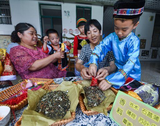 (180615) -- CHANGXING, June 15, 2018 (Xinhua) -- Children learn to make sachets under the guidance of folk artists to celebrate the upcoming Dragon Boat Festival at Baoqiao center kindergarten in Changxing County, east China\