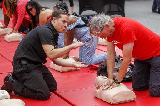 (180606) -- LOS ANGELES, June 6, 2018 (Xinhua) -- People take part in a hands-only CPR training during the Sidewalk CPR Day in Los Angeles, the United States, June 5, 2018. The American Heart Association joined local fire departments and emergency agencies to train thousands of residents on how to administer hands-only Cardiopulmonary Resuscitation. (Xinhua\/Zhao Hanrong)(jmmn)