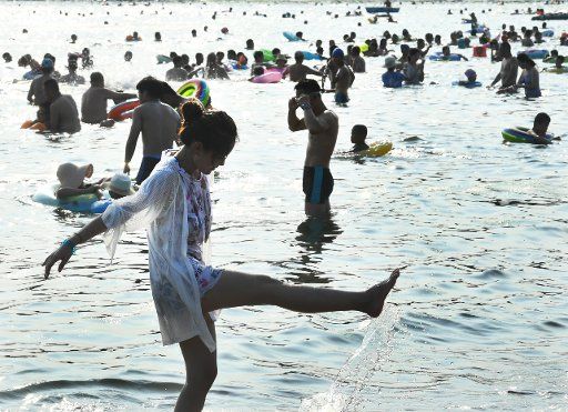 (180801) -- QINGDAO, Aug. 1, 2018 (Xinhua) -- People play with water on a beach in Qingdao, east China\