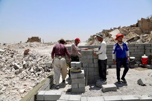(180710) -- MOSUL, July 10, 2018 (Xinhua) -- Workers reconstruct a house in the old city of Mosul, Iraq, July 5, 2018. One year after the Iraqi forces liberated the city of Mosul from Islamic State (IS) militants, tens of thousands of displaced residents are still living in tents, suffering the scorching summer with a temperature of over 50 degrees Celsius. TO GO WITH Feature: One year on, tens of thousands of Iraqis remain displaced from homes in Mosul (Xinhua\/Khalil Dawood) (jmmn)