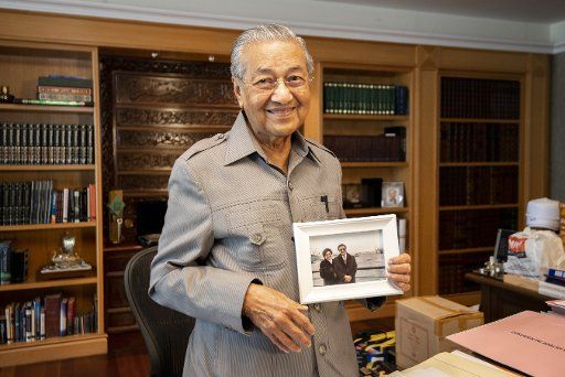 (180816) -- PUTRAJAYA, Aug. 16, 2018 (Xinhua) -- Malaysian Prime Minister Mahathir Mohamad demonstrates a picture showing his visit to China in the 1980s during an interview with Xinhua in Putrajaya, Malaysia, on Aug. 16, 2018. Mahathir Mohamad said Thursday that he would strengthen bilateral relations with China in his upcoming visit to China, citing historical bond between the two countries and close cooperation during his previous 22 years in office. (Xinhua\/Chong Voon Chung)(yg)