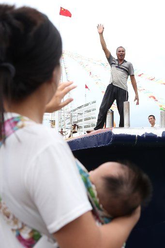 (180817) -- YANGJIANG, Aug. 17, 2018 (Xinhua) -- A woman holding her child bids farewell to her family member who sets sails for fishing in Yangjiang, south China\