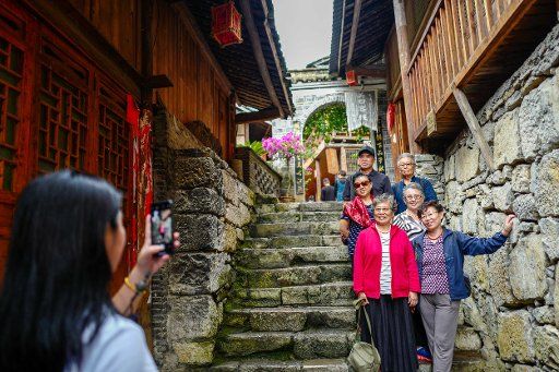 (180919) -- CHONGQING, Sept. 19, 2018 (Xinhua) -- Tourists pose for photos at Gongtan Ancient Town in Tujia-Miao Autonomous County of Youyang, southwest China\