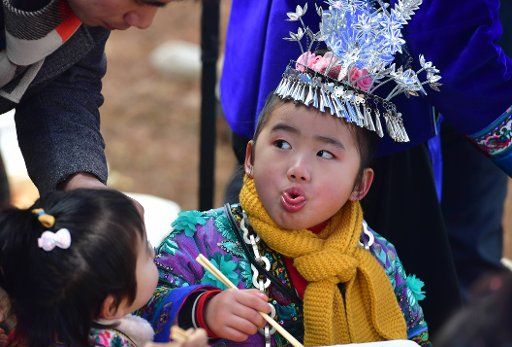 (190117) -- RONGSHUI, Jan. 17, 2019 (Xinhua) -- A girl of Miao ethnic group tastes food during the Lusheng festival in Dali Village, Miao Autonomous County of Rongshui, south China\
