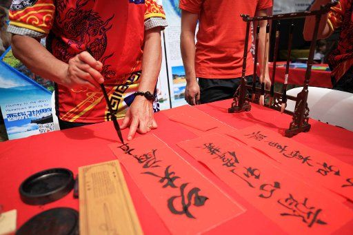 (190217) -- CANBERRA, Feb. 17, 2019 (Xinhua) -- A Chinese calligraphy artist writes at the 2019 National Multicultural Festival in Canberra, Australia, Feb. 16, 2019. The festival, held from February 15 to 17, provided a stage to various cultures around the world and mesmerized every visitor. (Xinhua\/Pan Xiangyue)