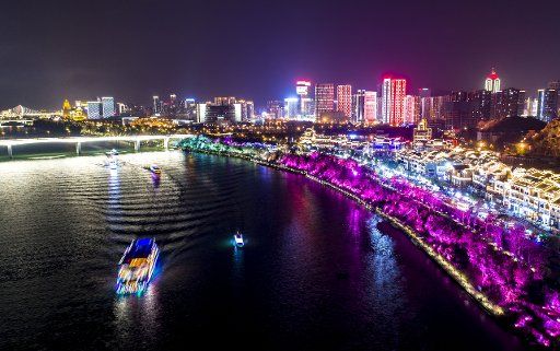 (190209) -- LIUZHOU, Feb. 9, 2019 (Xinhua) -- Tourists take boats to see the night view near the Ancient Town of Yaobu in Liuzhou City, south China\