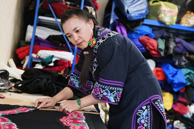 (190331) -- KUNMING, March 31, 2019 (Xinhua) -- Li Changzheng works at her workshop at the Chuxiong economic and technological development zone in Chuxiong, southwest China\