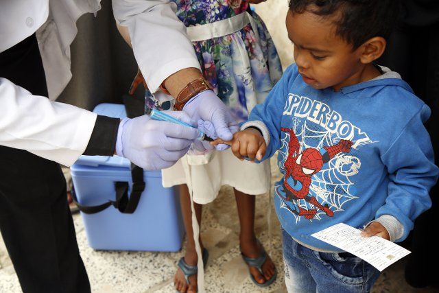 (190424) -- SANAA, April 24, 2019 (Xinhua) -- A medic puts a sign on the little finger of a child after he receives an anti-cholera vaccine against cholera in Sanaa, Yemen, on April 24, 2019. Yemeni Health Ministry in collaboration with WHO and UNICEF launched a 6-day home-to-home emergency immunization campaign against cholera in three most seriously affected districts in Sanaa with an aim to target all people from age of one year and above except pregnant women. (Xinhua\/Mohammed Mohammed