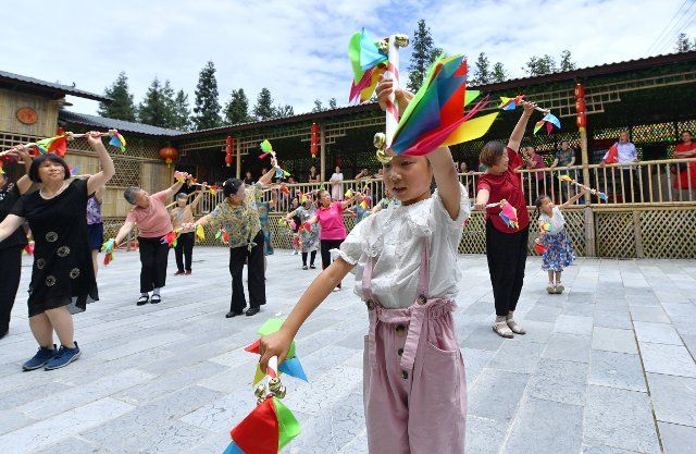 (190701) -- ENSHI, July 1, 2019 (Xinhua) -- Tourists learn a folk dance of the Tujia ethnic group while visiting the Chedongping tourism area in Zhushan Township of Xuan\