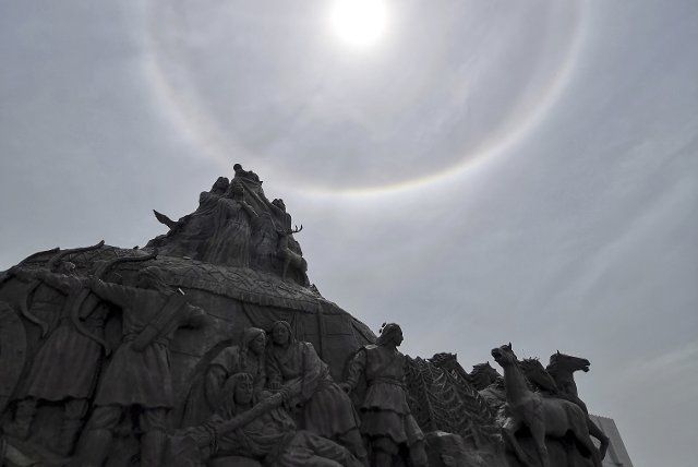 (190721) -- ERDOS, July 21, 2019 (Xinhua) -- A sculpture is silhouetted against a sun halo in Erdos, north China\
