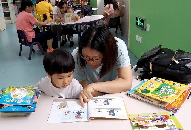 (190725) -- GUANGZHOU, July 25, 2019 (Xinhua) -- Children and their parents read books in Guangzhou Children\
