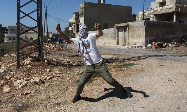 (191004) -- NABLUS, Oct. 4, 2019 (Xinhua) -- A Palestinian protester hurls stones at Israeli soldiers during clashes, after a protest against the expanding of Jewish settlements in Kufr Qadoom village near the West Bank city of Nablus, Oct. 4, 2019. (Photo by Nidal Eshtayeh\/Xinhua