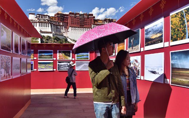 (191006) -- LHASA, Oct. 6, 2019 (Xinhua) -- Visitors view photographic works displayed during the 12th Tibet Qomolangma Photo Exhibition held on the square of the Potala Palace in Lhasa, capital of southwest China\