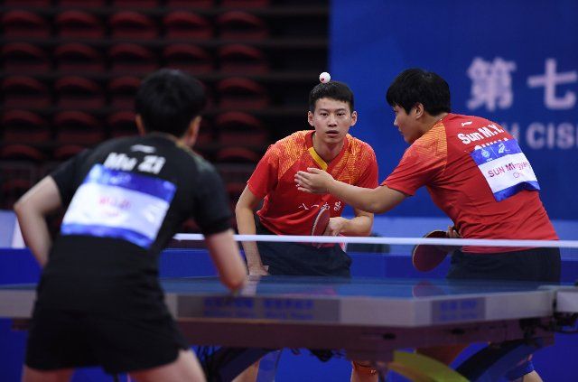(191023) -- WUHAN, Oct. 23, 2019 (Xinhua) -- Zhou Yu (C) and Sun Mingyang (R) of China compete during the mixed doubles final match of table tennis between at the 7th CISM Military World Games in Wuhan, capital of central China\