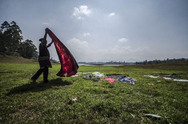 (191015) -- BANDUNG, Oct. 15, 2019 (Xinhua) -- A woman dries clothes near Cileunca dam in Bandung, Indonesia, Oct. 15, 2019. Villagers fish and wash clothes near the Cileunca dam when its water level recedes during dry seasons. (Photo by Septianjar\/Xinhua)