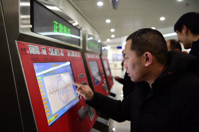 (191229) -- HOHHOT, Dec. 29, 2019 (Xinhua) -- A passenger operates a ticket machine in the Hohhot East station of the No. 1 metro line in Hohhot, north China\