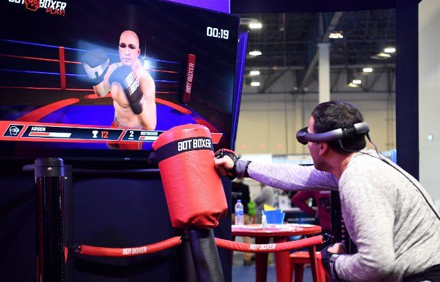 (200109) -- LAS VEGAS, Jan. 9, 2020 (Xinhua) -- A man experiences a VR (virtual reality) boxing game during the 2020 Consumer Electronics Show (CES) in Las Vegas, the United States, Jan. 8, 2020. The world\