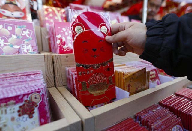 (200112) -- WESTMINSTER, Jan. 12, 2020 (Xinhua) -- A woman purchases red envelopes at the annual Lunar New Year Flower Festival 2020 in Westminster, the United States, Jan. 11, 2020. The Flower Festival, which is held from Jan. 3 to Jan. 23, draws thousands of people every day to shop flowers and gifts, celebrating the upcoming Lunar New Year. (Xinhua\/Li Ying)