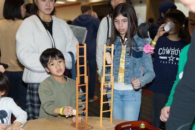 (200113) -- DALLAS, Jan. 13, 2020 (Xinhua) -- Children play a traditional Japanese game at the New Year celebration in Dallas, Texas, the United States, Jan. 12, 2020. Dallas\