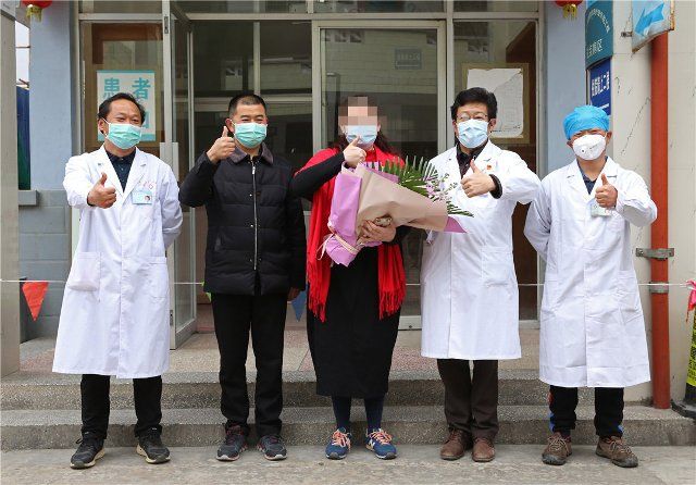 (200225) -- TENGCHONG, Feb. 25, 2020 (Xinhua) -- A cured coronavirus patient (C) poses for a group photo with medical workers before leaving Tengchong People\