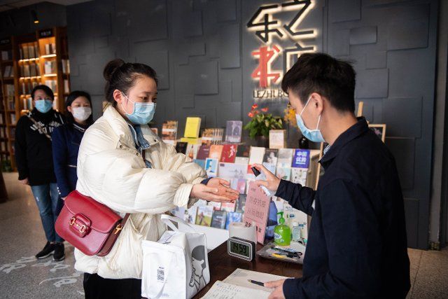 (200226) -- CHANGSHA, Feb. 26, 2020 (Xinhua) -- A woman gets her hands disinfected as she enters Lezhi bookshop in Tianxin District of Changsha, central China\