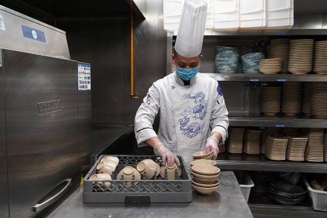(200322) -- CHENGDU, March 22, 2020 (Xinhua) -- A staff member arranges sterilized tableware at a restaurant in Chengdu, southwest China\