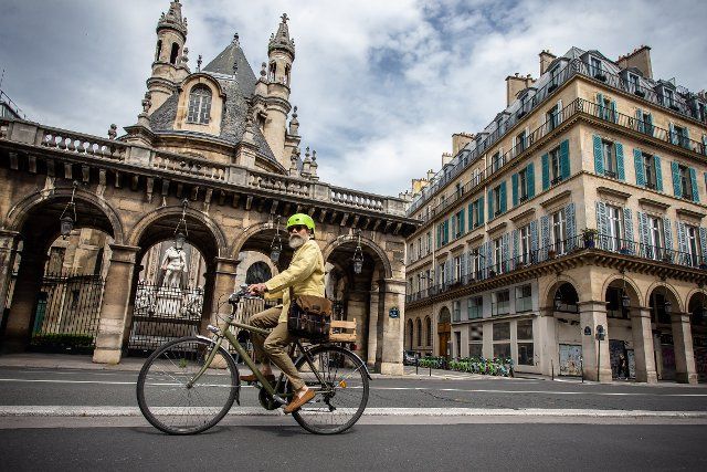(200509) -- PARIS, May 9, 2020 (Xinhua) -- A man rides a bicycle on the famous Rue de Rivoli in Paris, France, May 8, 2020. France would start to ease restrictions on movement from next Monday through "a very gradual process" which would stretch over several weeks at least to avoid a resurgence of COVID-19, Prime Minister Edouard Philippe confirmed on Thursday. Cycling is encouraged to reduce overcrowding on trains and buses in Paris, which has opened temporary bike lanes. The famous Rue de Rivoli has banned cars from running through. (Photo by Aurelien Morissard\/Xinhua)