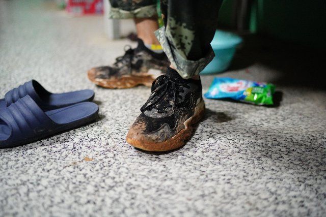 (200713) -- POYANG, July 13, 2020 (Xinhua) -- Li Qunqun takes off his shoes covered by mud after work in Poyang County, east China\