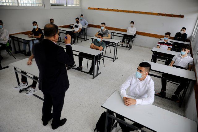 (200810) -- HEBRON, Aug. 10, 2020 (Xinhua) -- Students wearing face masks take a class on the first day of their new school year at a school in the West Bank city of Hebron, on Aug. 10, 2020. (Photo by Mamoun Wazwaz\/Xinhua