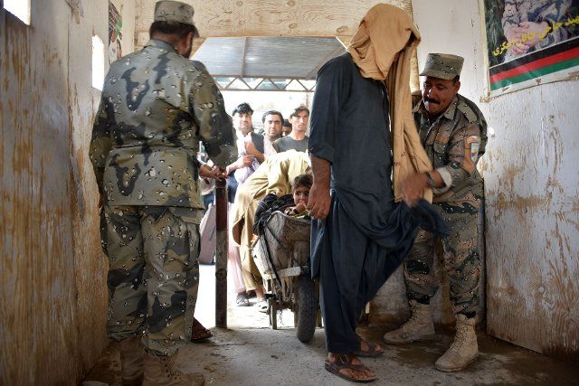 (200823) -- KANDAHAR, Aug. 23, 2020 (Xinhua) -- An Afghan border forces member checks a man after he returned from Pakistan at the Spin Boldak district of Kandahar province, Afghanistan, Aug. 22, 2020. The Afghan government has reopened the Spin Boldak border following its closure due to the COVID-19 pandemic. (Photo by Sanaullah Seiam\/Xinhua