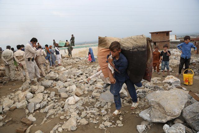 (200826) -- CHARIKAR, Aug. 26, 2020 (Xinhua) -- A man carries his belongings from a damaged house after a flood in Charikar, Parwan province, Afghanistan, Aug. 26, 2020. The death toll of floods during Tuesday night in Afghanistan\