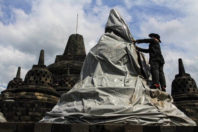 (201112) -- MAGELANG, Nov. 12, 2020 (Xinhua) -- A worker covers the stupa at Borobudur temple with tarpaulin for prevention of an anticipated volcanic eruption of Mount Merapi in Magelang, central Java, Indonesia, Nov. 12, 2020. (Photo by Joni\/Xinhua