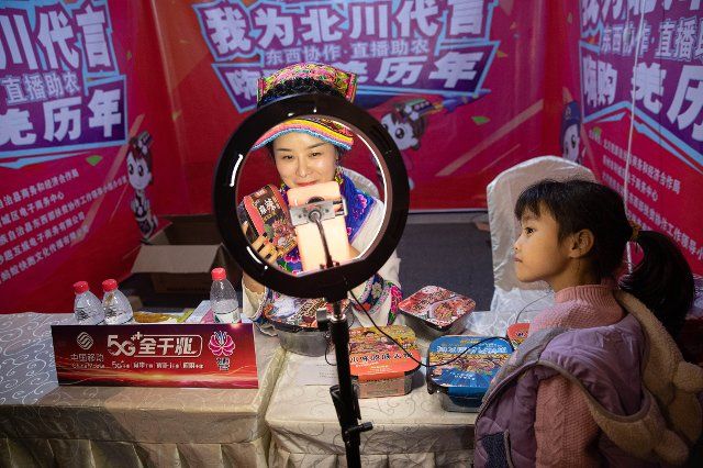 (201115) -- BEICHUAN, Nov. 15, 2020 (Xinhua) -- A child watches a livestreamer selling local products in Beichuan County, southwest China\