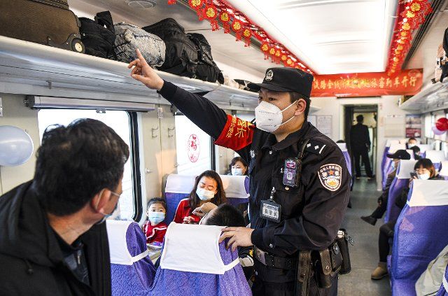 (201209) -- URUMQI, Dec. 9, 2020 (Xinhua) -- Railway police officer Zhou Chunyang performs security check on passenger train K9756 from Korla to Yetimbulak, northwest China\