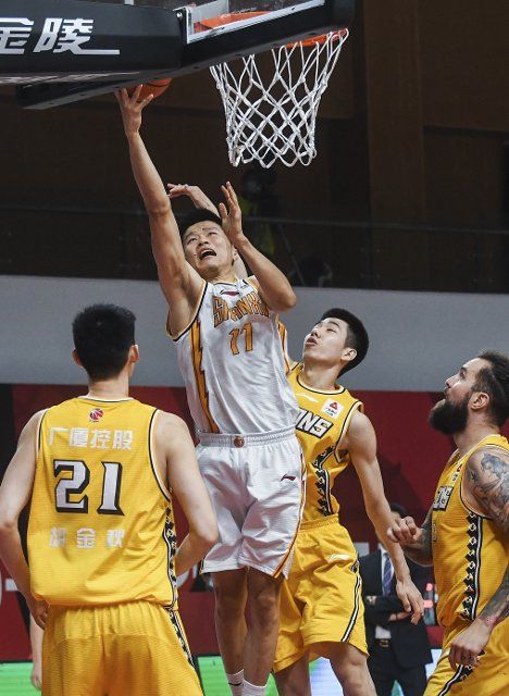 (201210) -- ZHUJI, Dec. 10, 2020 (Xinhua) -- Liu Guancen (top) of Shanxi Loongs goes for a lay-up during the 16th round match between Zhejiang Lions and Shanxi Loongs at the 2020-2021 season of the Chinese Basketball Association (CBA) league in Zhuji, east China\