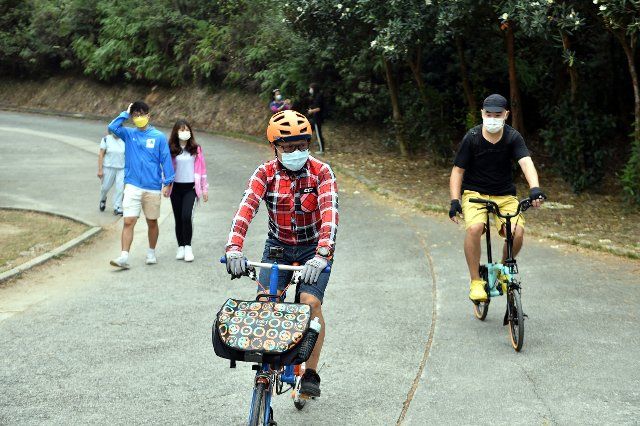 (201212) -- HONG KONG, Dec. 12, 2020 (Xinhua) -- Citizens go outing at a park with face masks worn, as a way to support Hong Kong Special Administrative Region (HKSAR) government\
