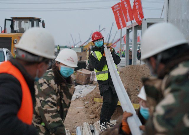(210120) -- SHIJIAZHUANG, Jan. 20, 2021 (Xinhua) -- Cao Zepan (C) works at the construction site of Huangzhuang Apartment COVID-19 quarantine center in Shijiazhuang, north China\