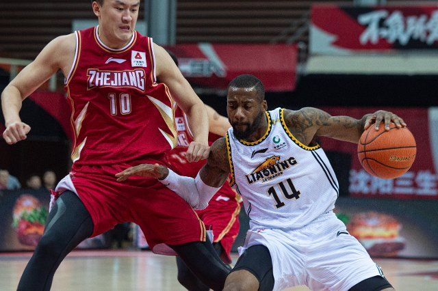 (210103) -- ZHUJI, Jan. 3, 2021 (Xinhua) -- Jonathan Simmons (R) of Liaoning Flying Leopards dribbles during the 26th round match between Liaoning Flying Leopards and Zhejiang Golden Bulls at the 2020-2021 season of the Chinese Basketball Association (CBA) league in Zhuji, east China\