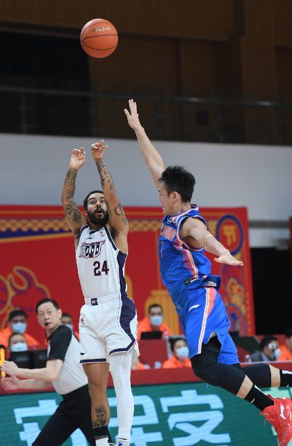 (210201) -- ZHUJI, Feb. 1, 2021 (Xinhua) -- Dallas Moore (L) of Guangzhou Loong Lions shoots during the 37th round match between Sichuan Blue Whales and Guangzhou Loong Lions at the 2020-2021 season of the Chinese Basketball Association (CBA) league in Zhuji, east China\
