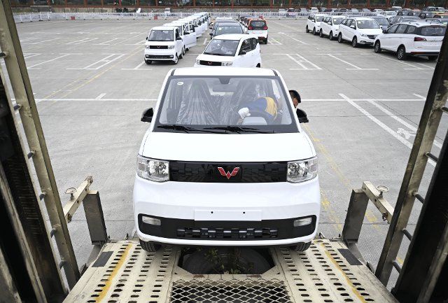 (210308) -- LIUZHOU, March 8, 2021 (Xinhua) -- A worker drives a new energy vehicle into a transport vehicle at a logistics park in Liuzhou, south China\