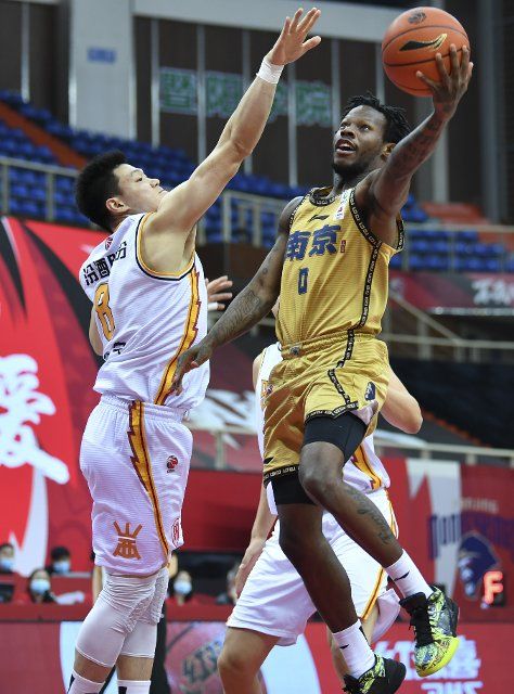 (210315) -- ZHUJI, March 15, 2021 (Xinhua) -- Sean Hill (R) of Nanjing Monkey Kings goes to the basket past Zhang Ning of Shanxi Loongs during the 46th round match between Nanjing Monkey Kings and Shanxi Loongs at the 2020-2021 season of the Chinese Basketball Association (CBA) league in Zhuji, east China\