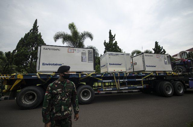 (210302) -- BANDUNG, March 2, 2021 (Xinhua) -- An Indonesian solider stands guard near trucks loaded with raw materials for the Sinovac COVID-19 vaccine at Bio Farma in Bandung, Indonesia, March 2, 2021. (Photo by Septianjar\/Xinhua