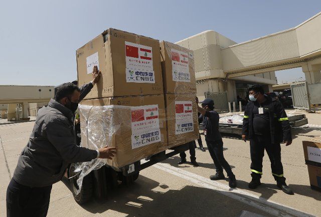 (210407) -- BEIRUT, April 7, 2021 (Xinhua) -- Staff transport the Sinopharm vaccines donated by China at the Rafic Hariri International Airport in Beirut, Lebanon, April 6, 2021. Two batches of Sinopharm vaccines donated by China arrived in Lebanon on Tuesday. (Photo by Bilal Jawich\/Xinhua
