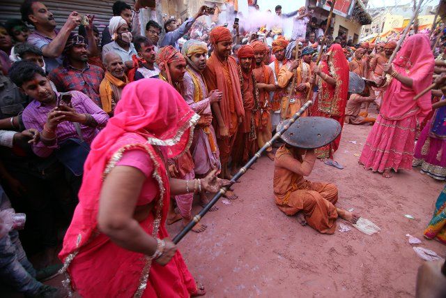 (210324) -- NEW DELHI, March 24, 2021 (Xinhua) -- Indian women from Barsana village beat a villager from Nandgoan with wooden sticks during Lathmar Holi festival celebrations at Barsana village in Uttar Pradesh, India on March 23, 2021. (Str\/Xinhua