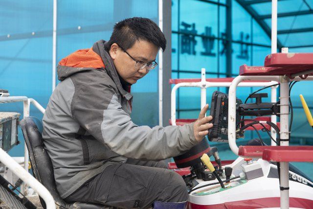 (210511) -- JIANSANJIANG, May 11, 2021 (Xinhua) -- A staff member inspects an unmanned transplanter in a smart agriculture demonstration zone administered by Hongwei Farm Co., Ltd. of Beidahuang Group in northeast China\