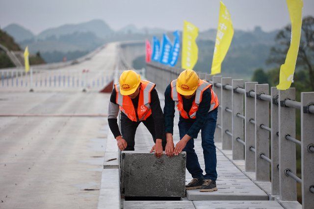 (210421) -- DUSHAN, April 21, 2021 (Xinhua) -- Photo taken on April 20, 2021 shows workers carry out construction on the grand bridge of Guiyang-Nanning high-speed railway in Dushan County, southwest China\